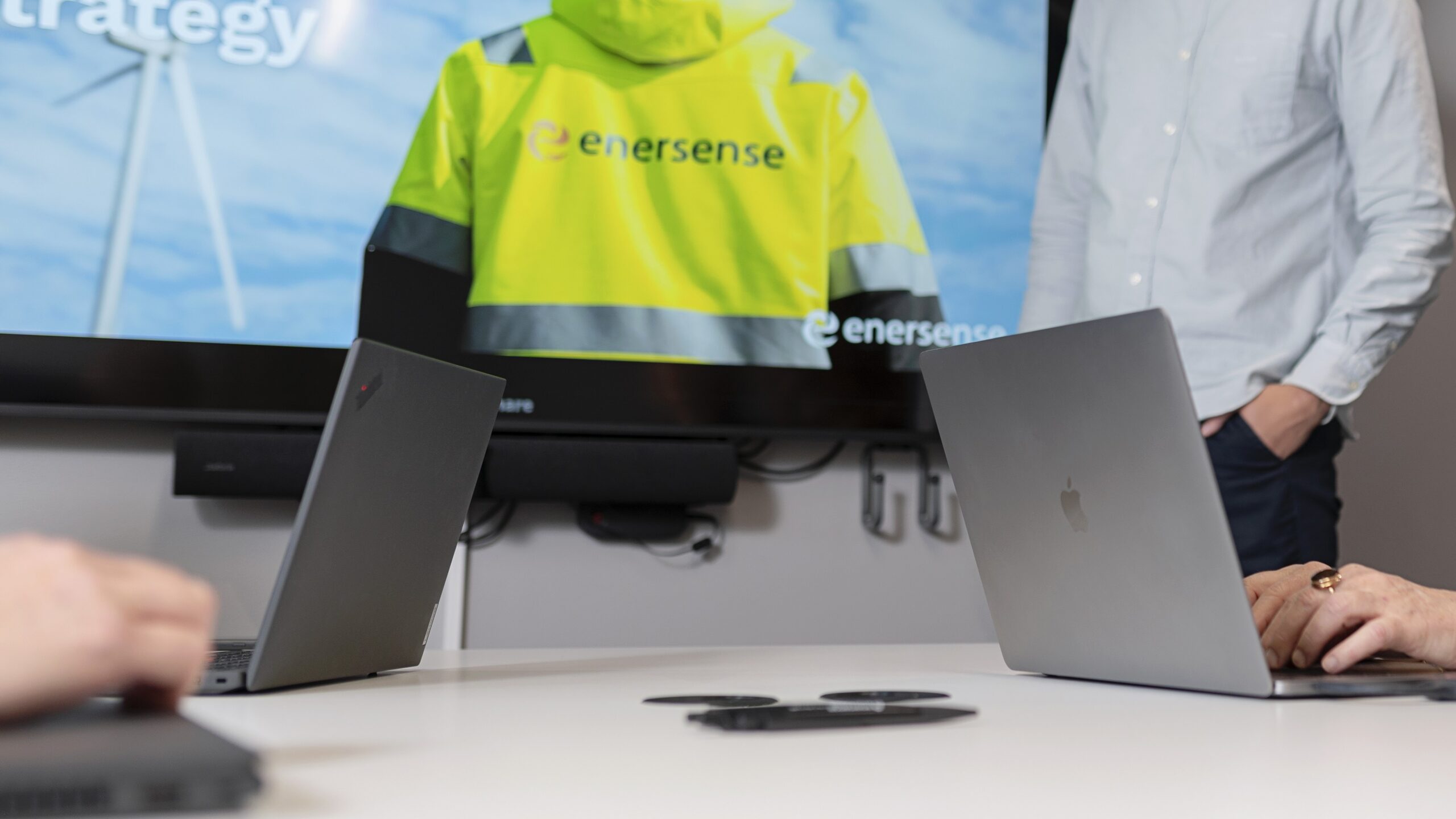 Business meeting at Enersense office with presentation materials and laptops